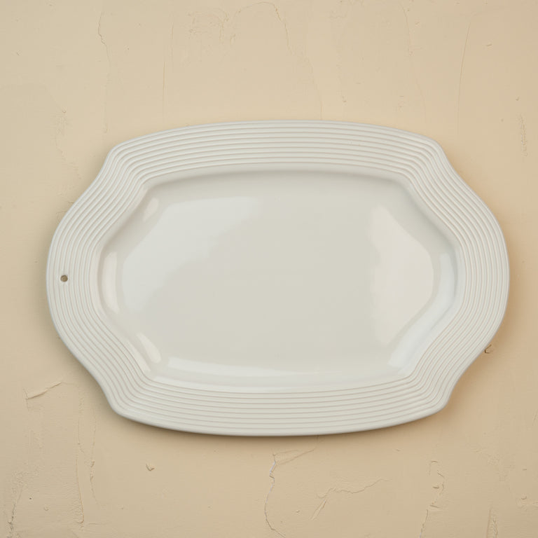 Pretty Platter: Cream-colored oval ceramic serving dish with a ribbed rim and scalloped edges.