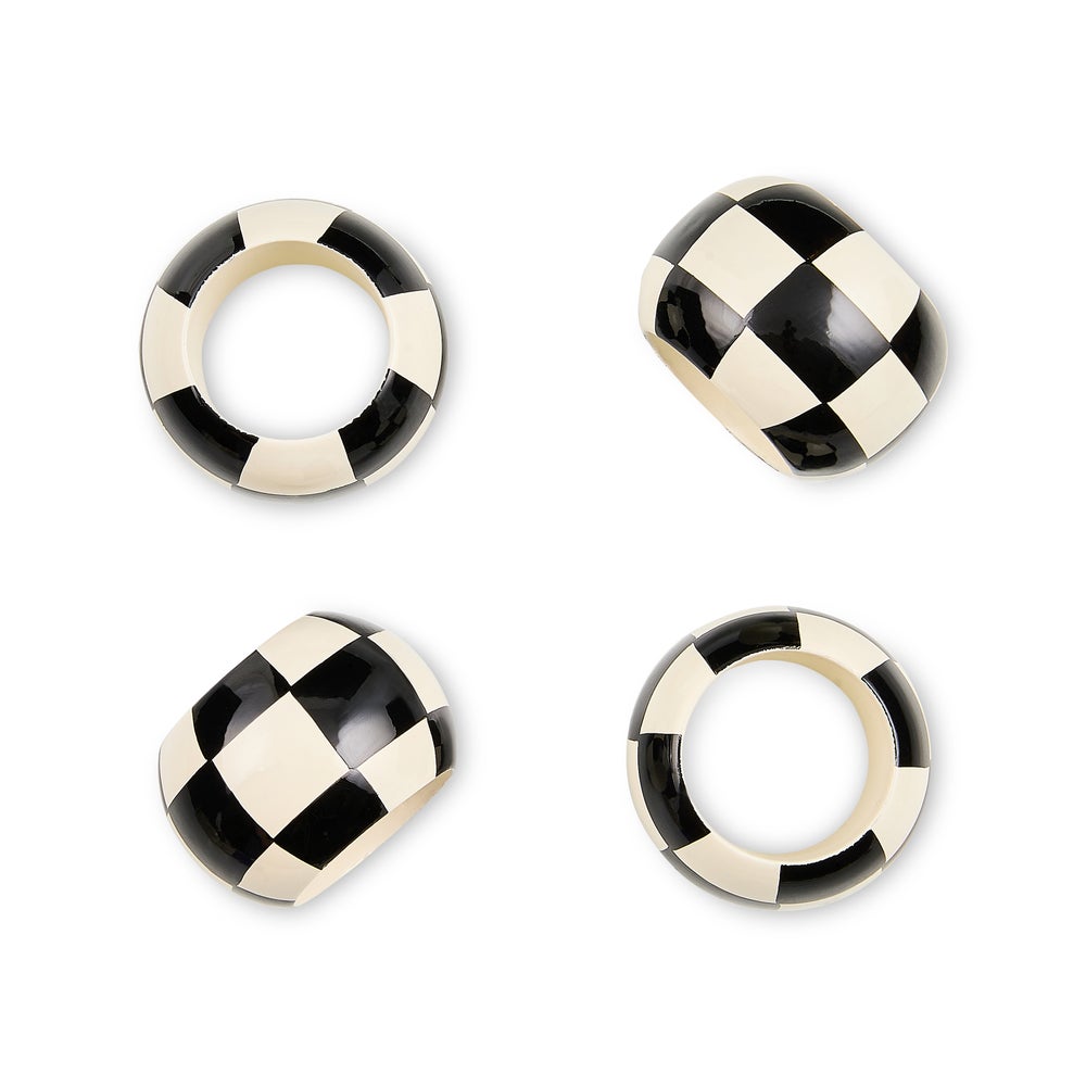 Set of four wooden napkin rings with a black and white checkered pattern.