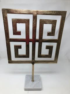 Golden square accent decor with a Greek key pattern on a white marble base.