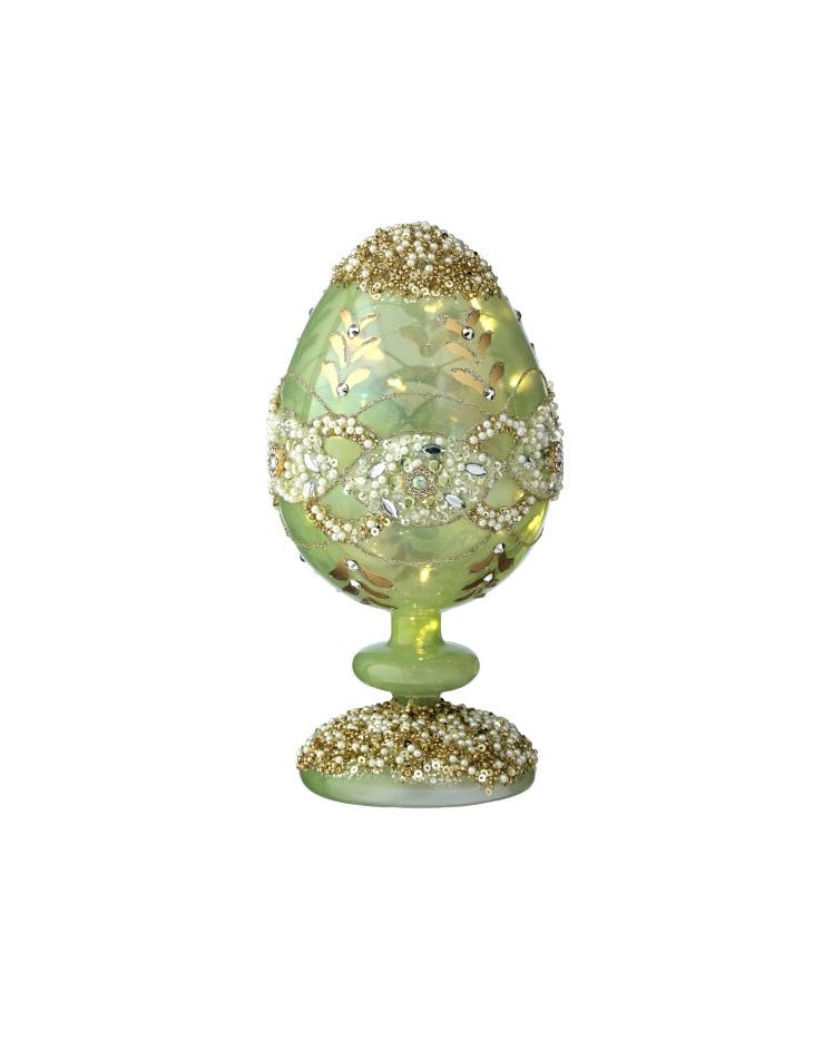 8-inch glass pedestal egg with warm white LED lights and sparkling jewel accents on a faceted surface.