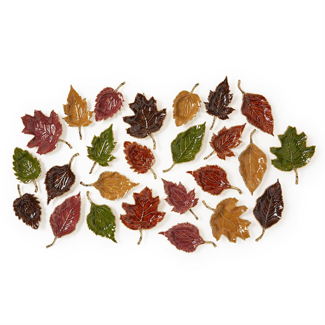 Assorted enameled leaf trays in five shapes and autumn colors like red, green, gold, and brown.