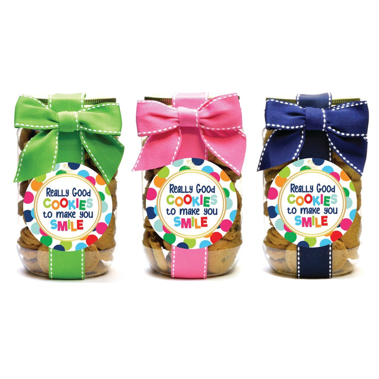 Three pint-sized cookie jars with green, pink, and blue ribbons and colorful polka dot labels.