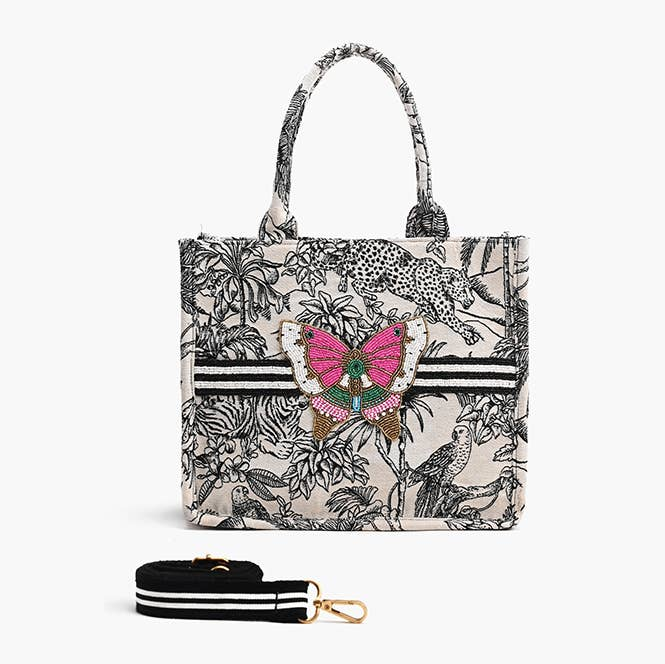 Forbidden Tote in hand-woven jacquard with jungle print, beaded butterfly, and adjustable strap.