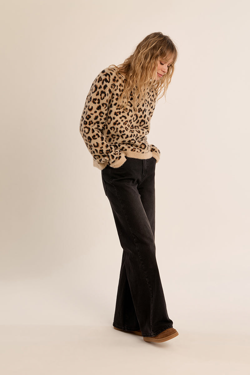 Woman wearing the Cathy Ladies Knitted Sweater in a leopard print with black wide-leg jeans.