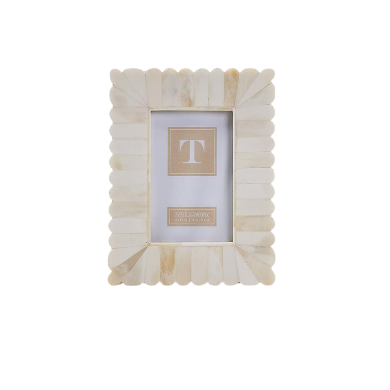 Scalloped bone photo frame with a cream and tan sunburst pattern and vertical stand.
