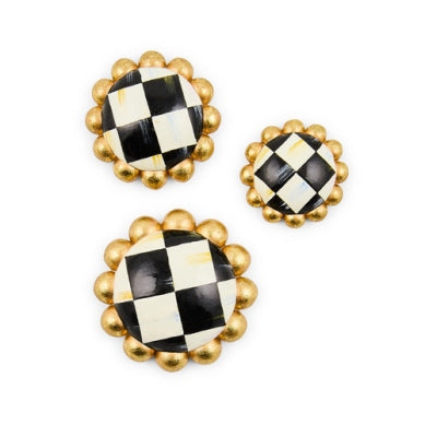 Three round MacKenzie-Childs magnets in small, medium, and large with black and white check pattern.