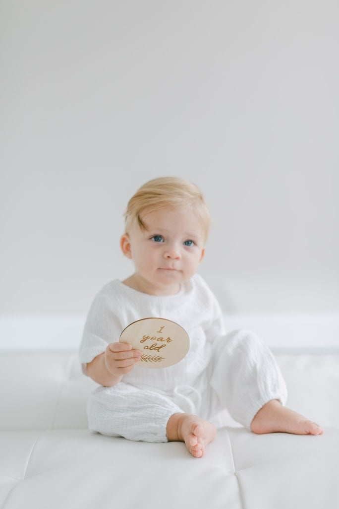 Natural basswood baby milestone cards set with engraved text including Hello World I'm Here and growth measurements.
