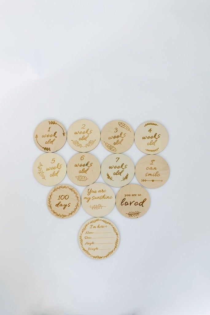 Set of natural basswood baby milestone cards with engraved text including Hello World I'm Here and growth measurements.