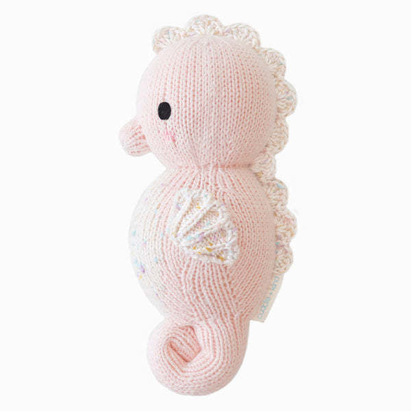 Hand-knit powder pink baby seahorse toy made with soft cotton yarn.