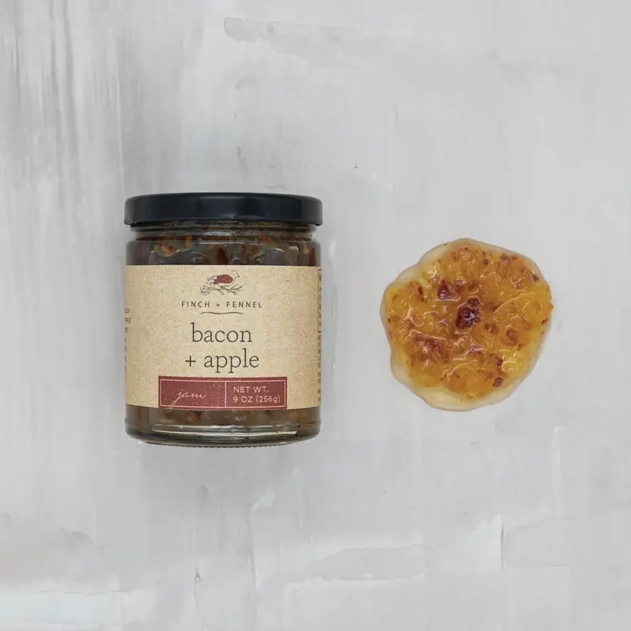 Jar of sweet and savory bacon apple jam with visible fruit pieces.