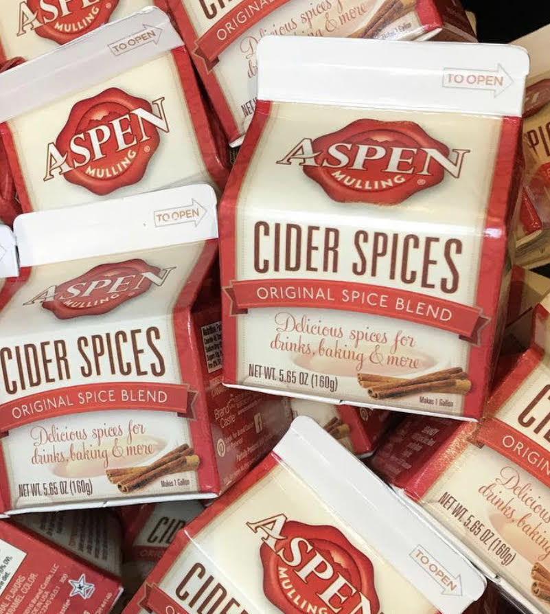 Multiple cartons of Aspen Mulling Original Spice Blend Cider Spices with cinnamon stick graphics.