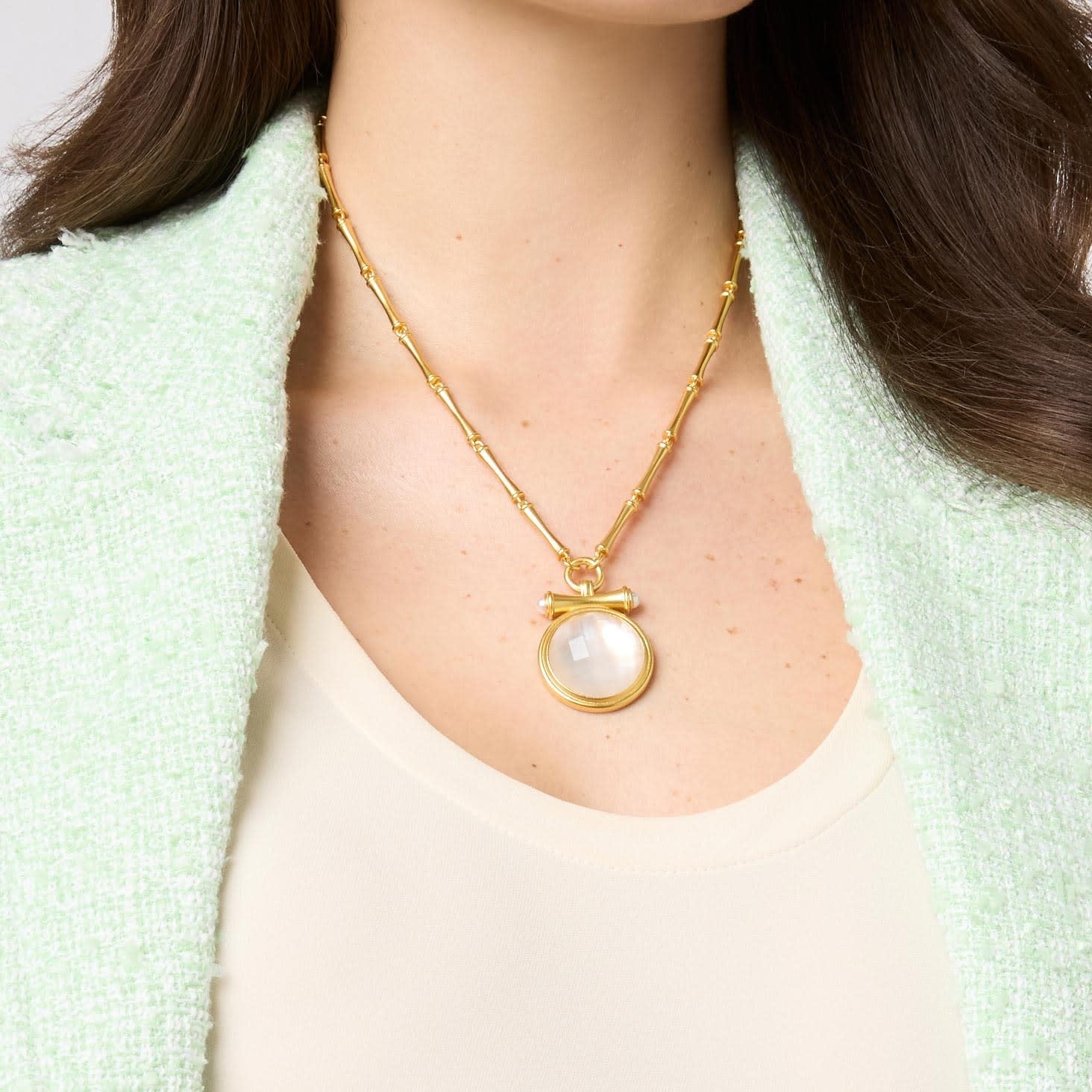 Adjustable bamboo link chain necklace with golden pendant featuring glass pearl cap over round gemstone.