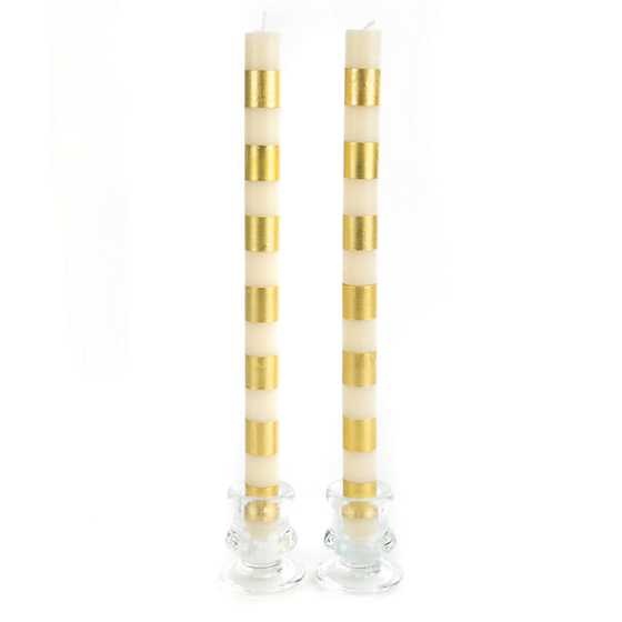 Set of gold beeswax paraffin blend dinner candles with a bands pattern and cylindrical silhouette.