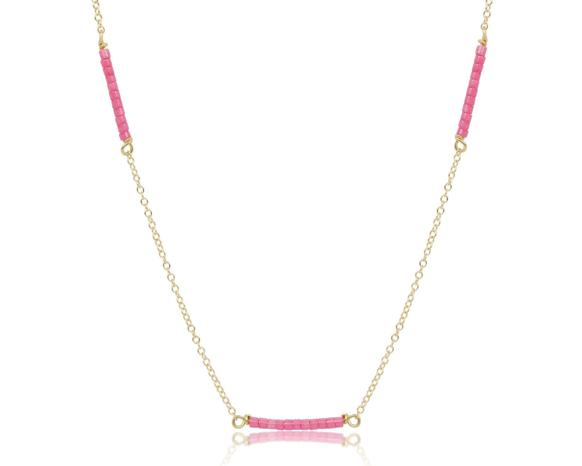 Gold-filled chain choker necklace with colorful seed beads on a light background