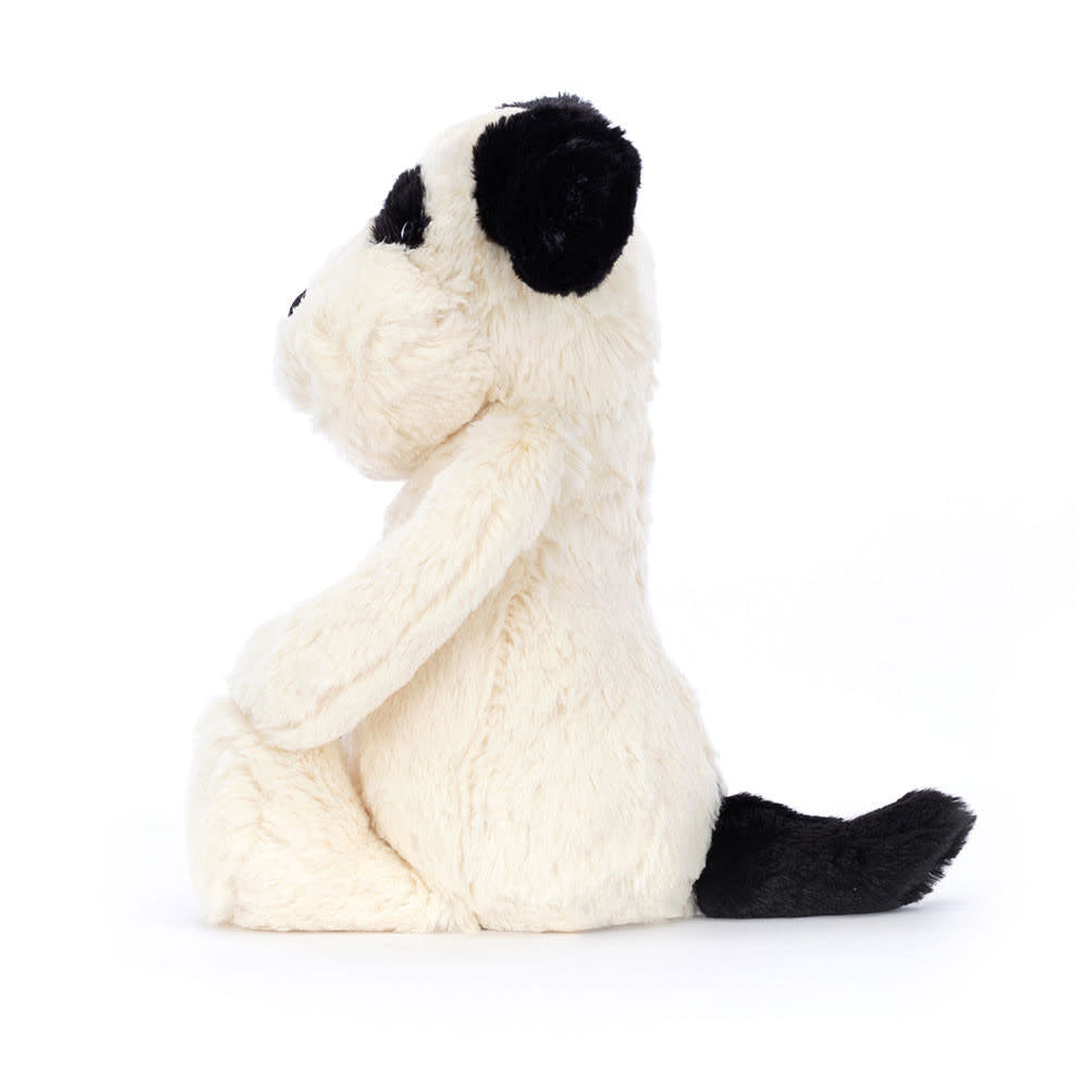 Medium-sized Bashful plush puppy with black and cream polyester fur, smudgy facial patch, sooty tail, sitting pose.