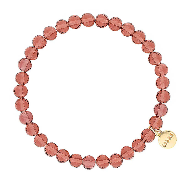 Lizas Quadro Big crystal stretch bracelet in dusty rose with a gold logo charm.