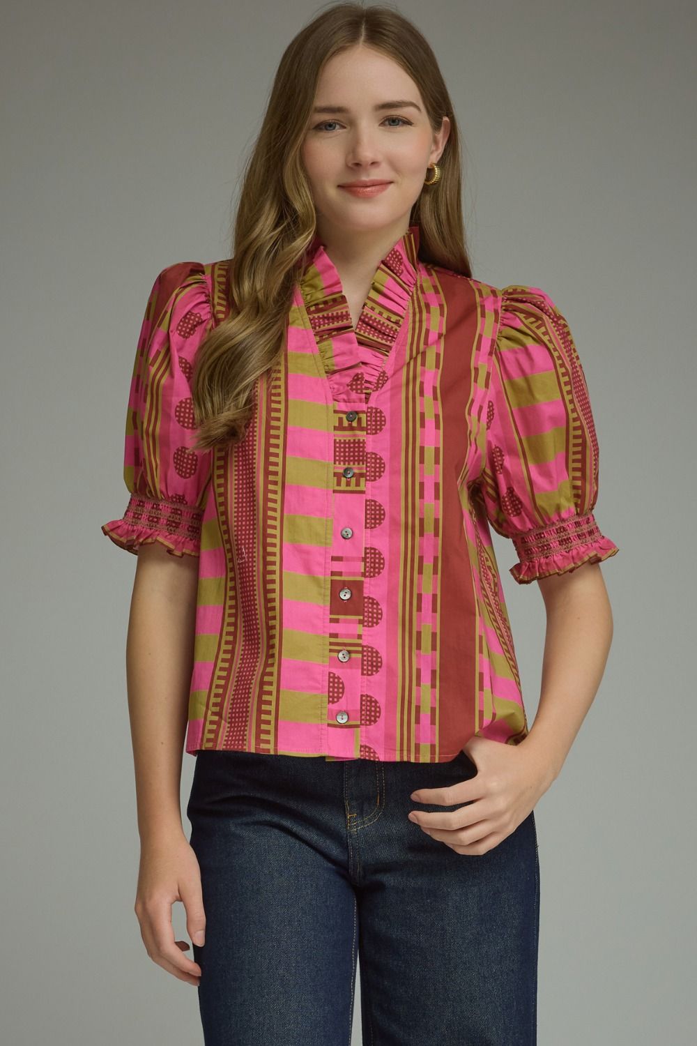 Woman wearing the Athena mixed print short puff sleeve top in pink and olive with dark denim jeans.