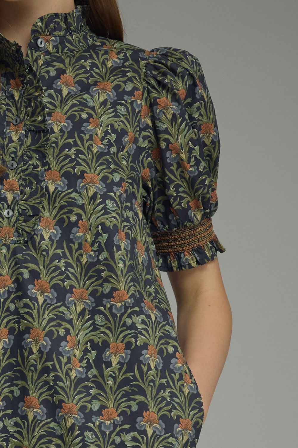 Close-up of a floral print midi dress with a ruffled high neck and short puff sleeves.
