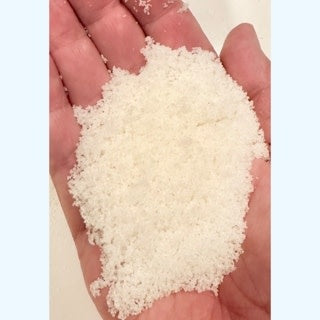 Glass jar of Beach Grass & Dune bath salts with beige granules.