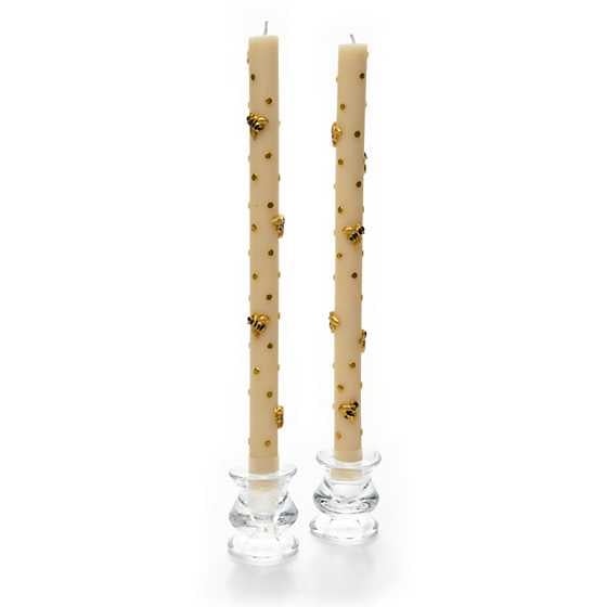 Set of three tall pure beeswax dinner candles in natural honey color with steady warm flames.