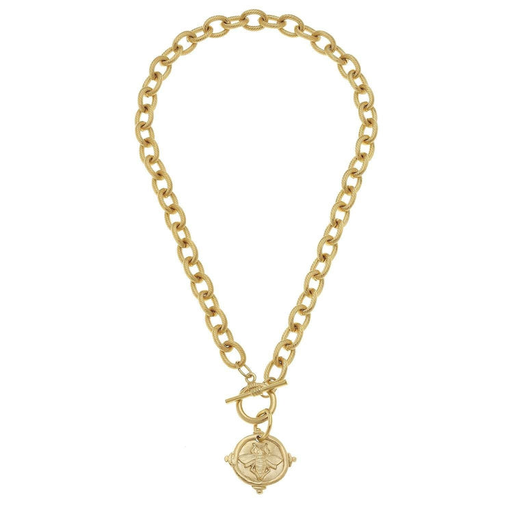 Triple-plated gold bee intaglio pendant on a textured chain necklace with toggle clasp.