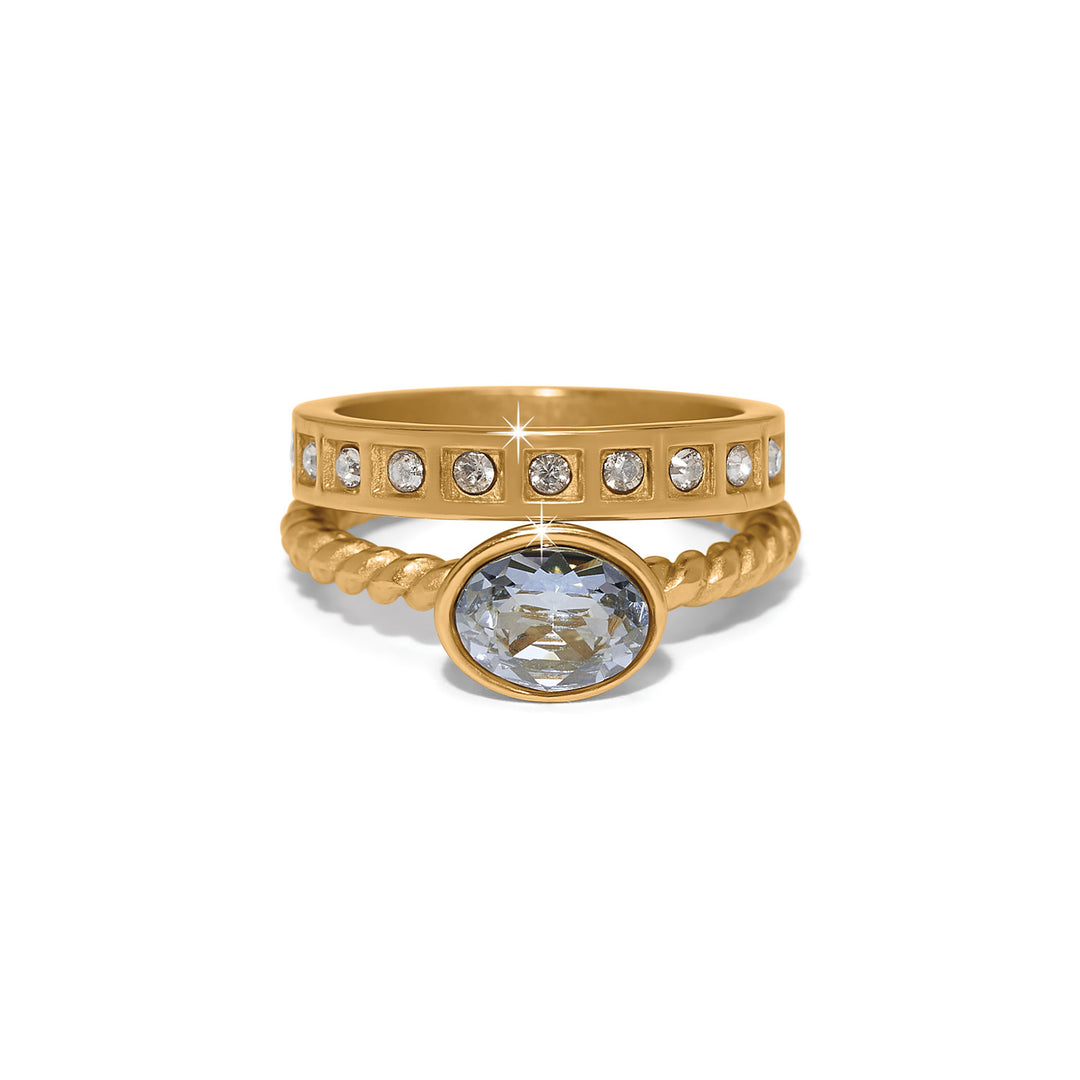Love Knows Duo Rings featuring a gold-plated band with crystals and a twisted band with a blue gem.