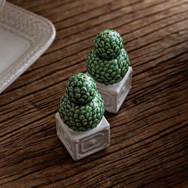 Hand-painted ceramic topiary salt and pepper shakers in berry tones with green foliage accents.