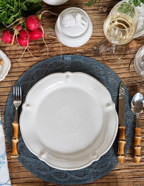 White ceramic flared dinner plate with a fluted rim silhouette