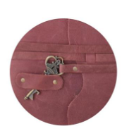 Close-up of a maroon leather journal featuring an antique brass key closure and metal rivets.
