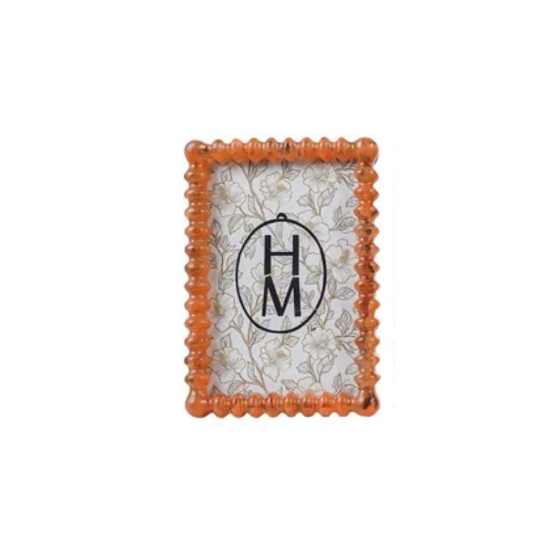 Orange marbled resin spindle frame with scalloped edges and a floral pattern insert.