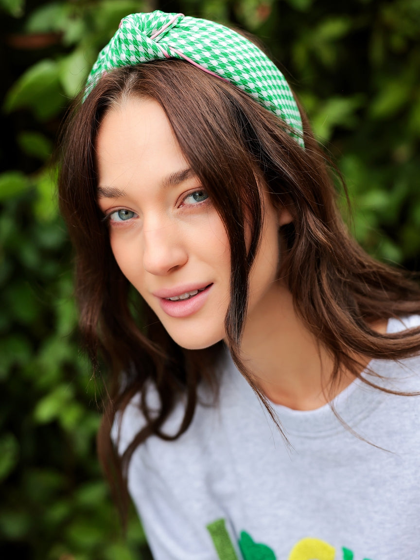 Green houndstooth knotted headband with a soft fabric texture.
