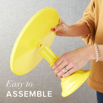 A person screws the yellow base into the top plate of a melamine cakestand.