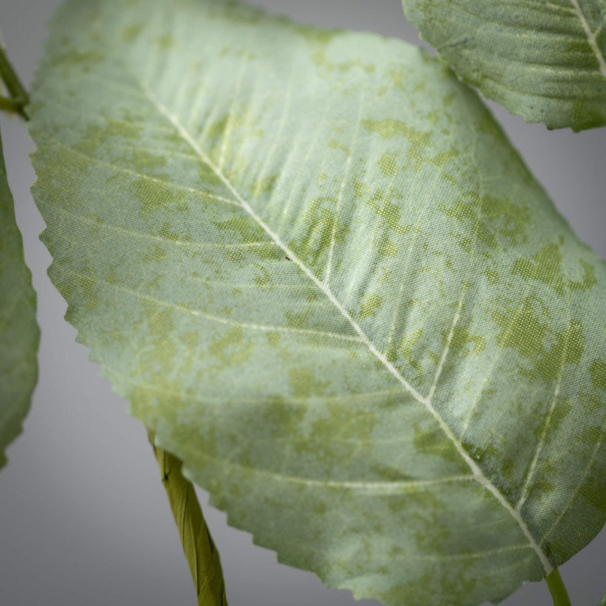 Long artificial lemon leaf spray with flexible polyester stems in natural green foliage.