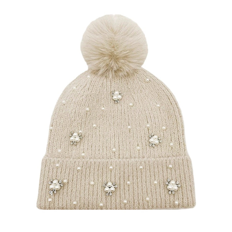 Black knit beanie with fluffy pom pom top, pearl studs around the brim.