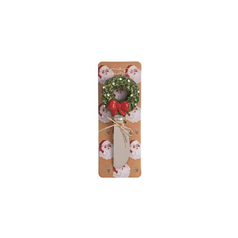 Christmas spreader with a hand-painted green wreath stoneware handle and red bow on a display card.