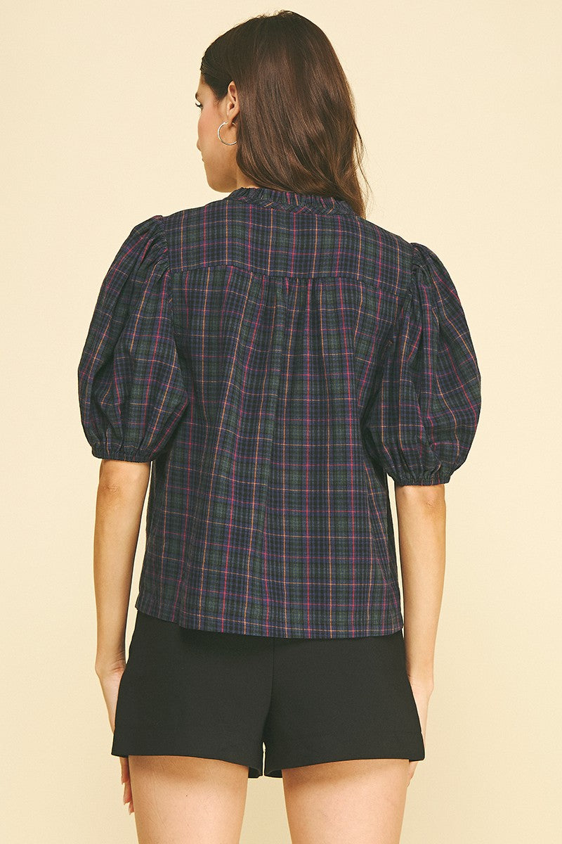 Back view of a woman wearing the April Plaid Puff Sleeve Blouse in a dark navy and green tartan.