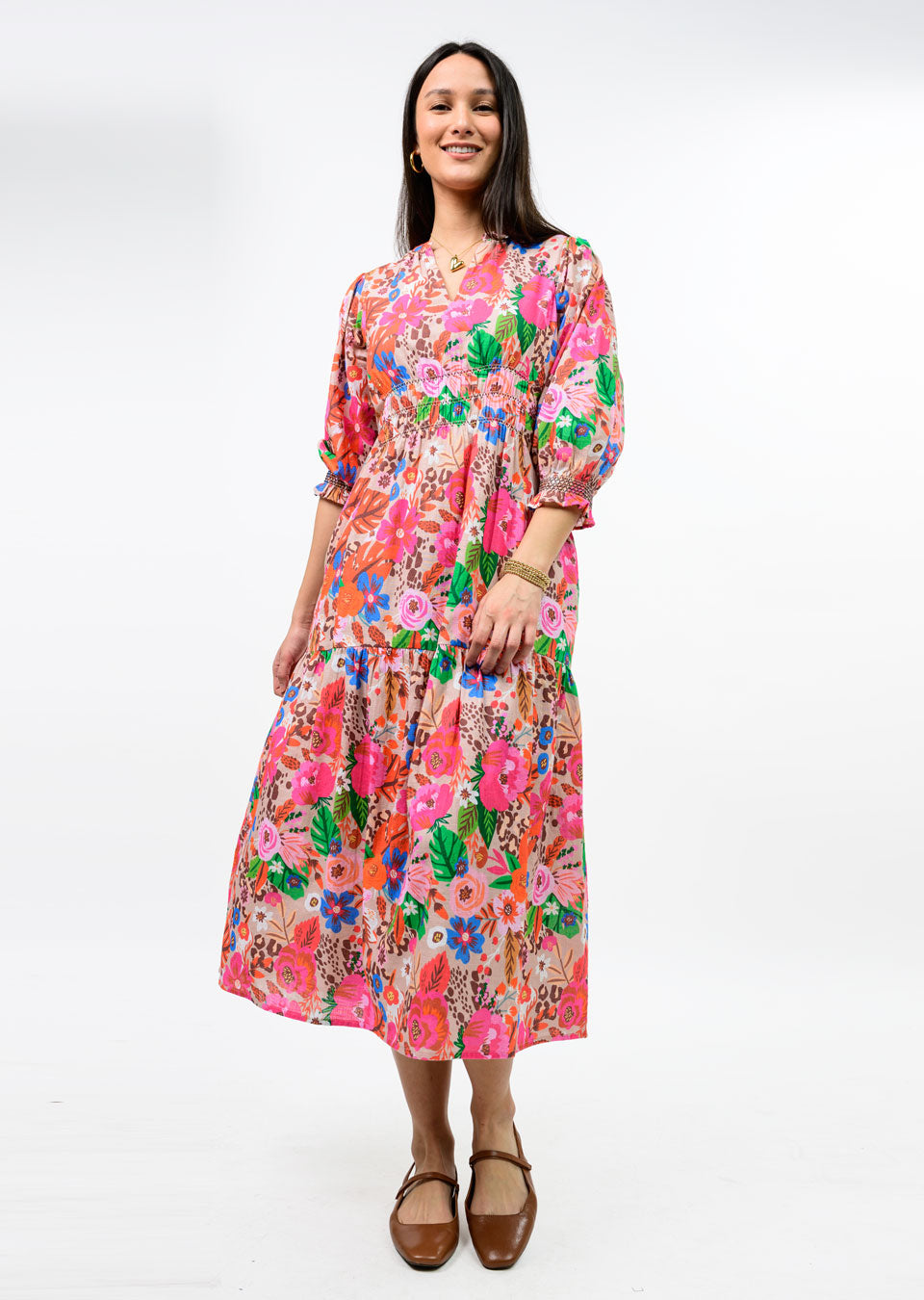 Woman wearing the Elise Floral Smocked Tiered Maxi Dress with 3/4 puff sleeves and a V-neckline.