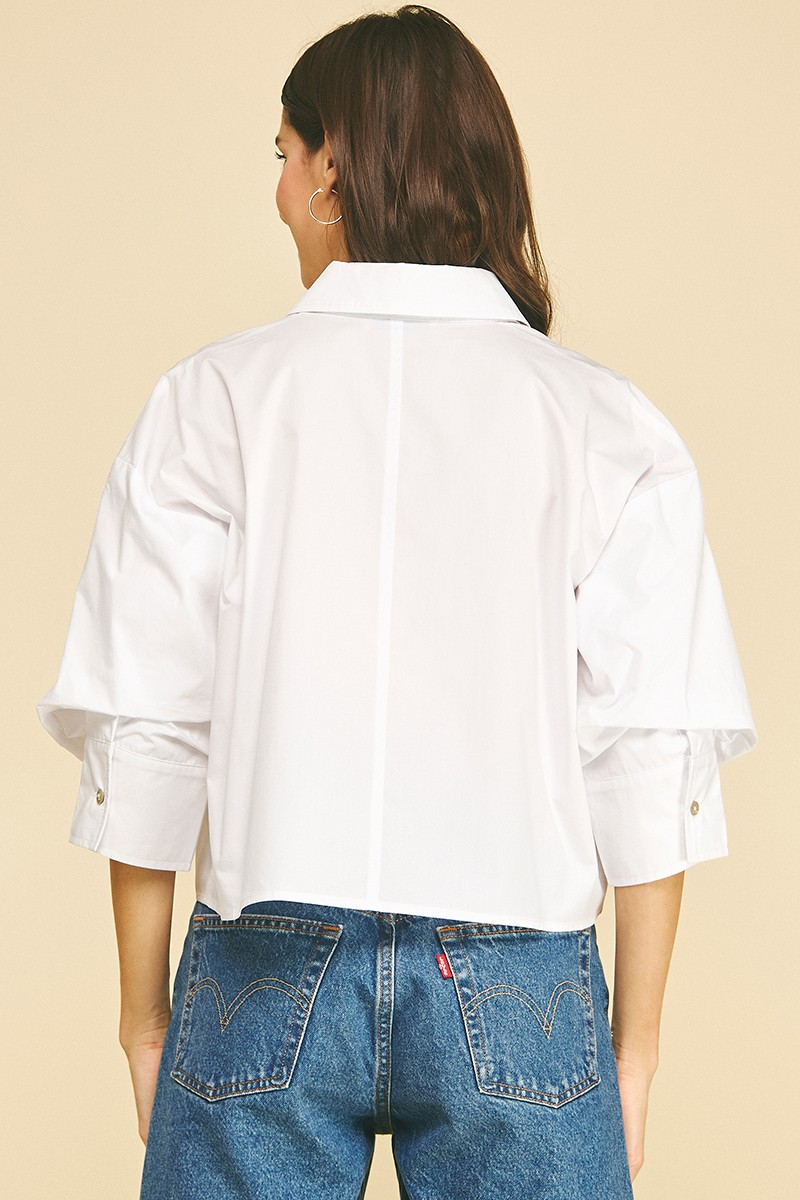 Back view of a white cropped button-down shirt with tuck detailed 3/4 sleeves and a classic collar.