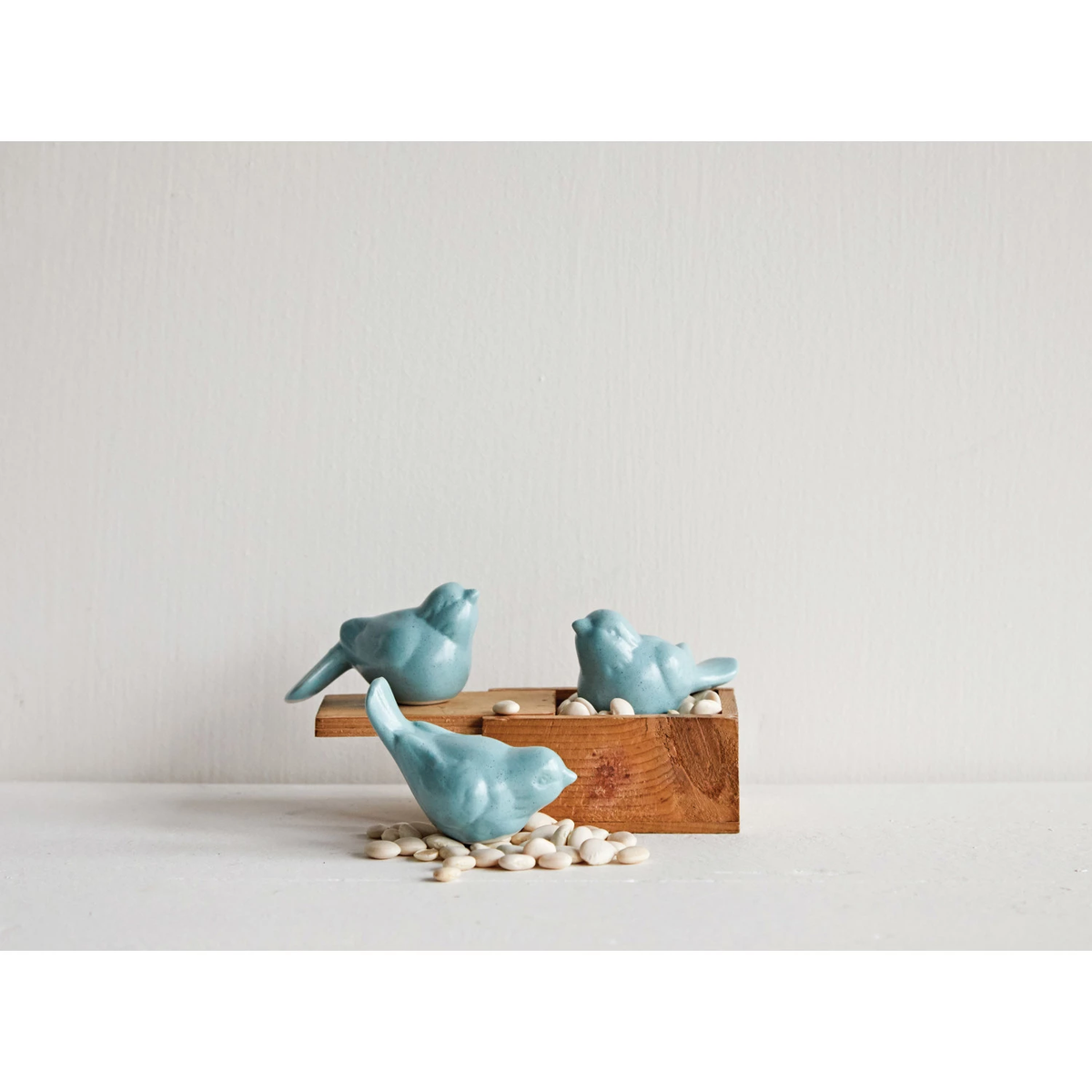 Ceramic bird figurine in aqua glaze with smooth rounded silhouette.