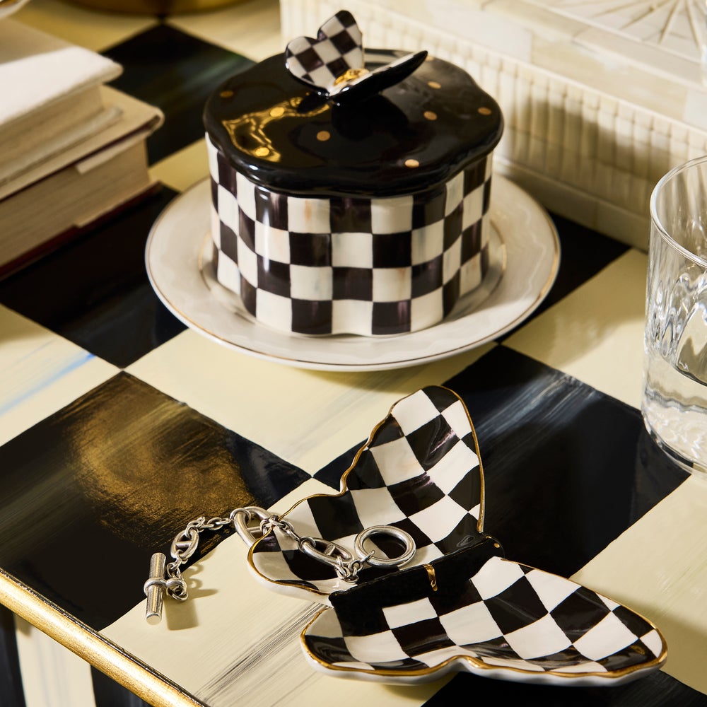 Two hand-painted ceramic butterfly trinket dishes with a black and white checkered pattern.
