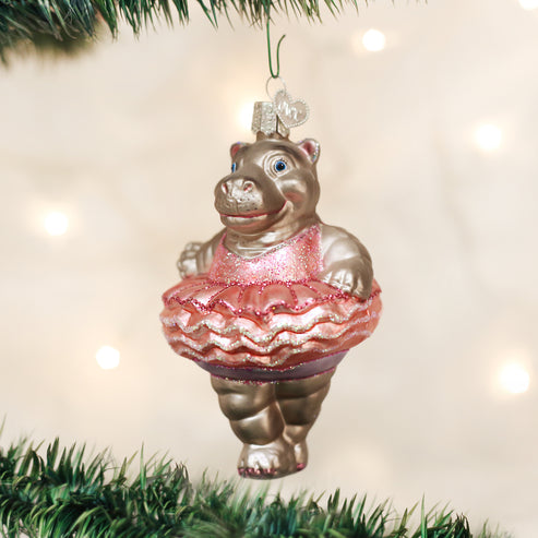 Twinkle Toes glass ornament featuring a hippo ballerina in a pink glittery tutu on a Christmas tree.