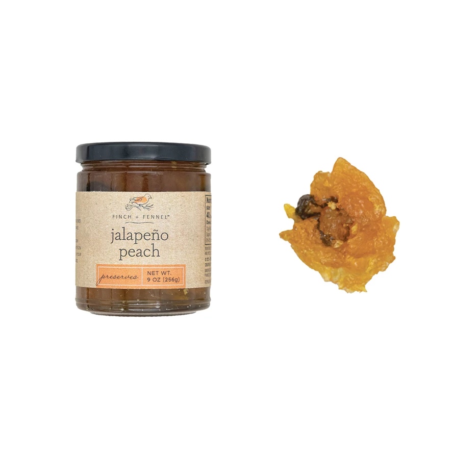 A 9 oz jar of Finch + Fennel Jalapeño Peach Preserves next to a sample of the orange fruit spread.