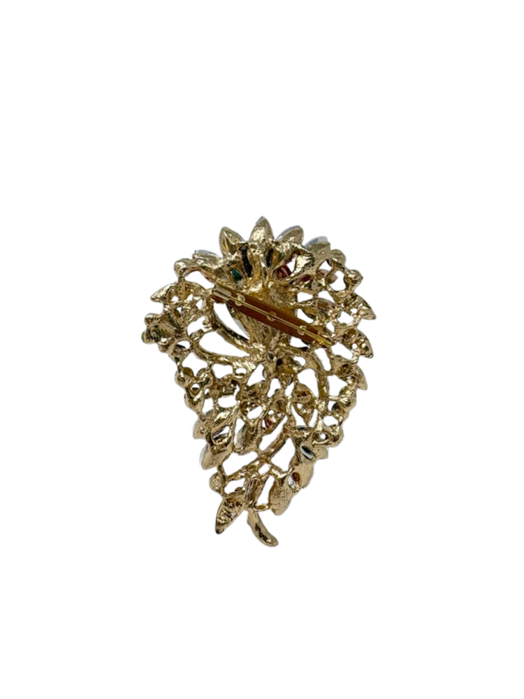 Back view of a gold-tone multi-gemstone statement brooch with a pin fastening.