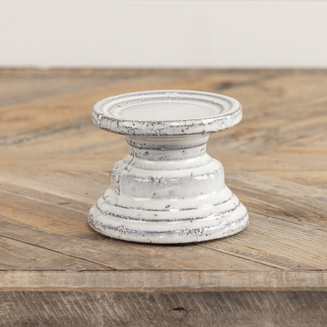 Terracotta cream pillar candle stand with a square four-inch silhouette.