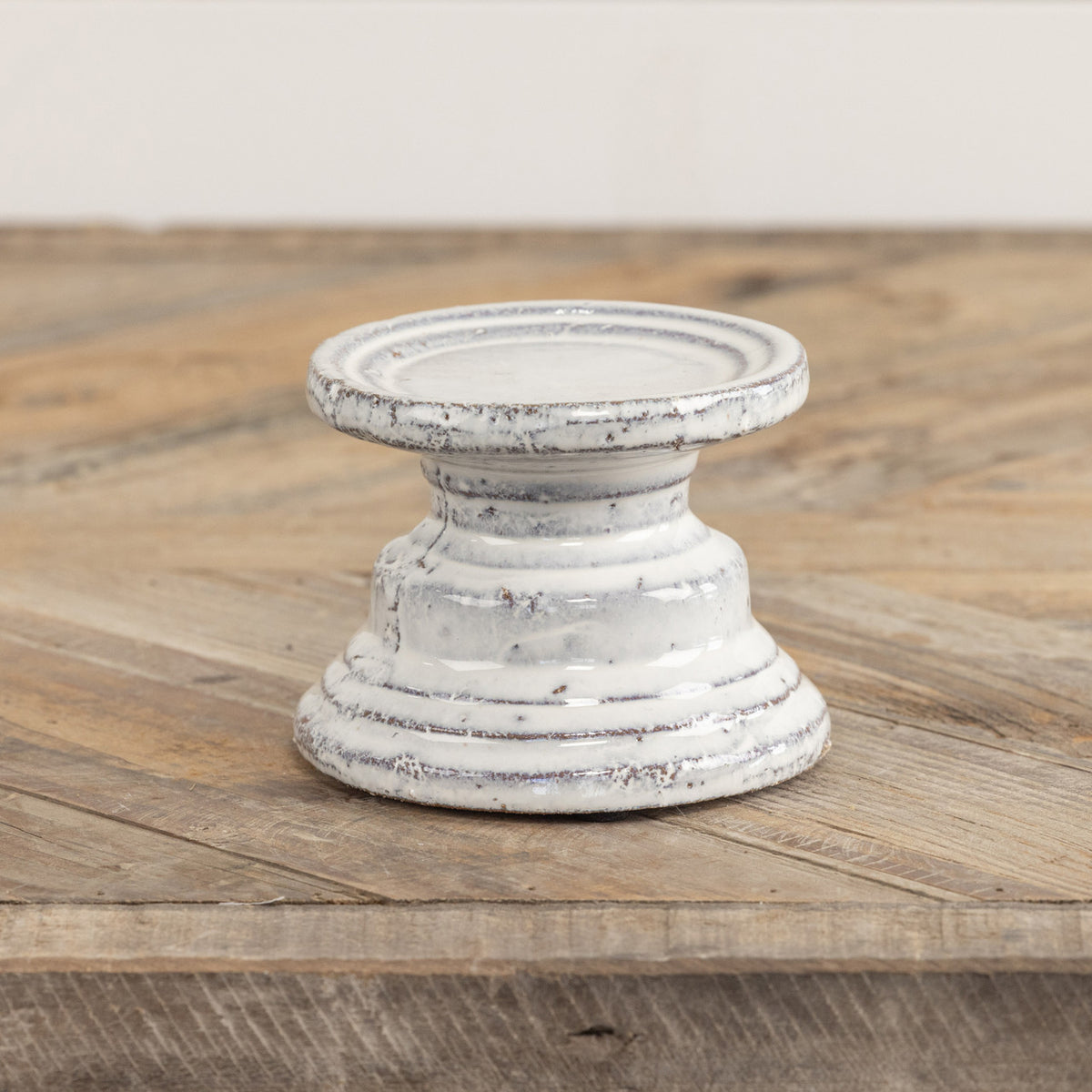 Terracotta cream pillar candle stand with a square four-inch silhouette.