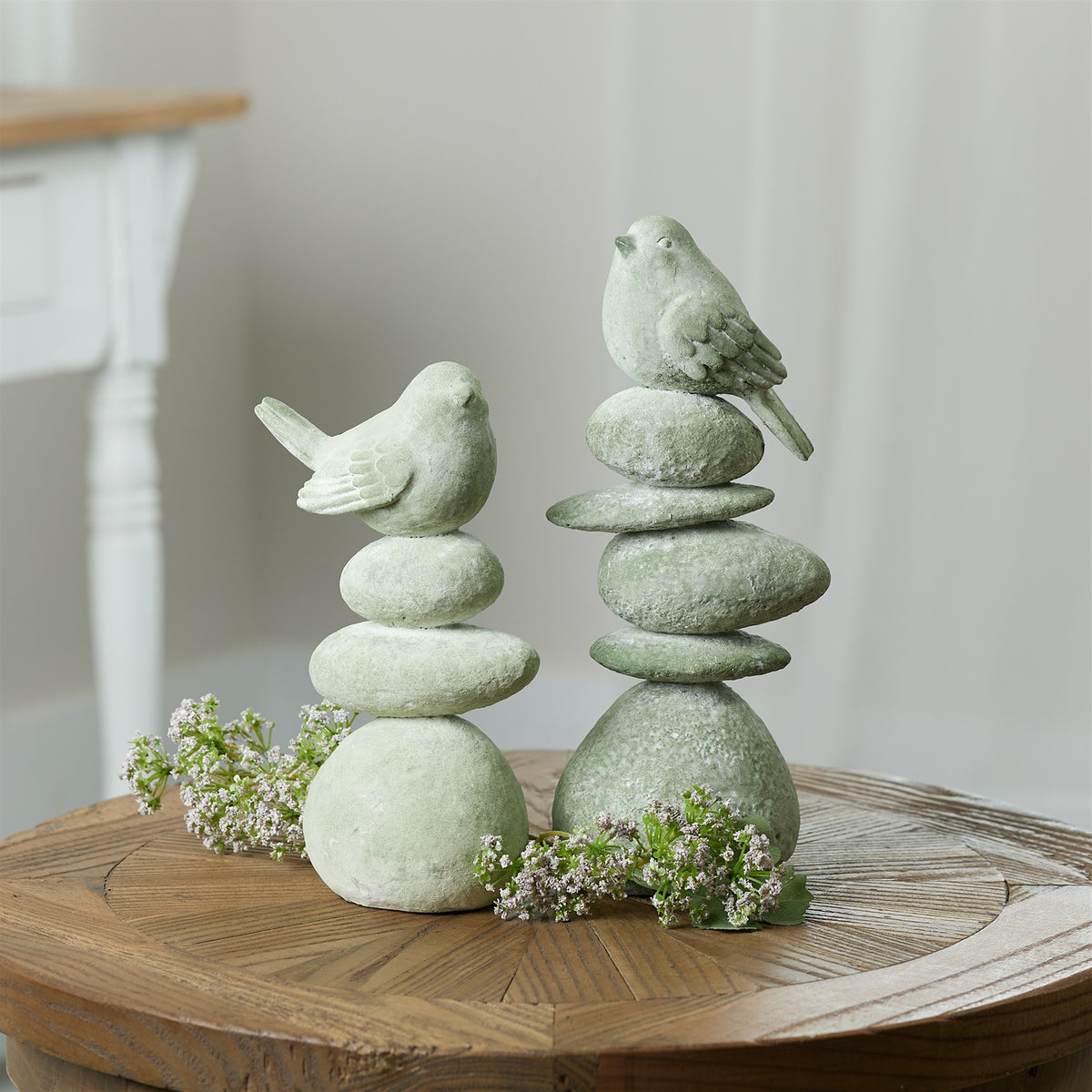 Resin figurine of a bird perched on smooth rocks with realistic nature-inspired design.