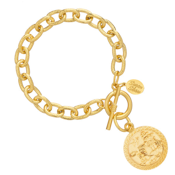 Gold chain link bracelet with a toggle clasp and a circular Blue Willow pattern coin pendant.