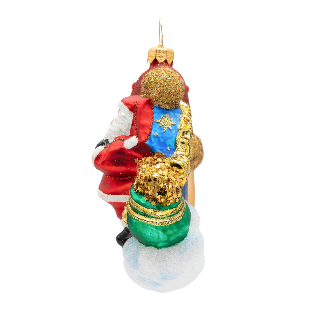Side view of a Crescent Wishes Santa glass ornament showing Santa with a green bag of gold stars.