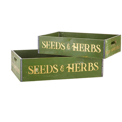 Two green wooden crates with gold lettering that reads "SEEDS & HERBS".