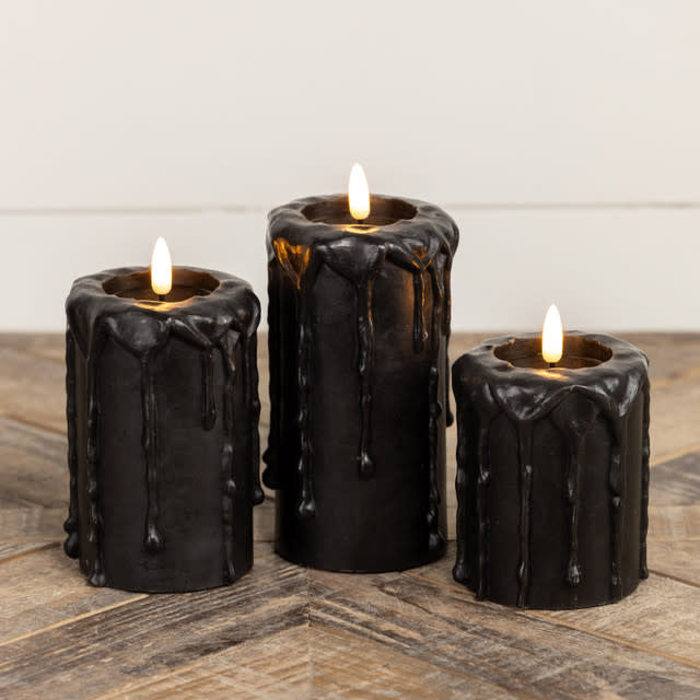 Black plastic pillar candle with realistic wax texture and a glowing three-dimensional flame effect.